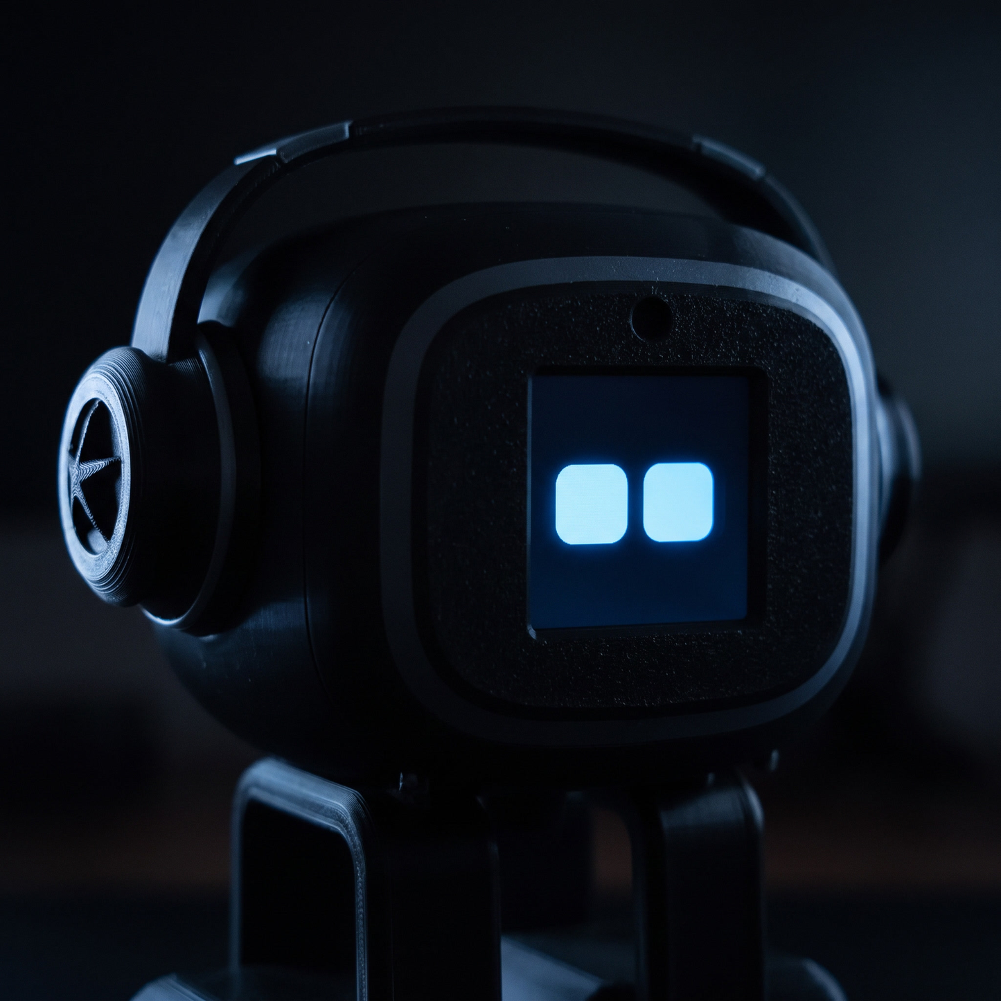 Close-up of NIMBO desk robot face with glowing blue eyes in the dark